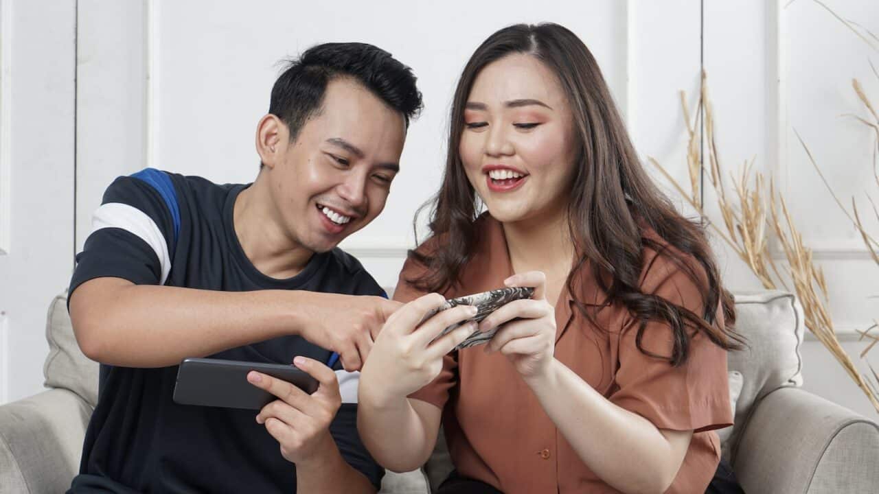 man and woman sitting on sofa chair inside room